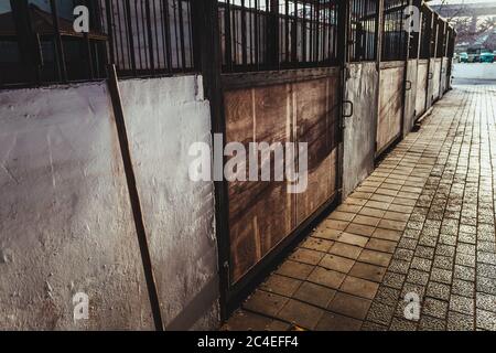 Stalla vuota con porte di legno sporche in una fattoria. Foto Stock