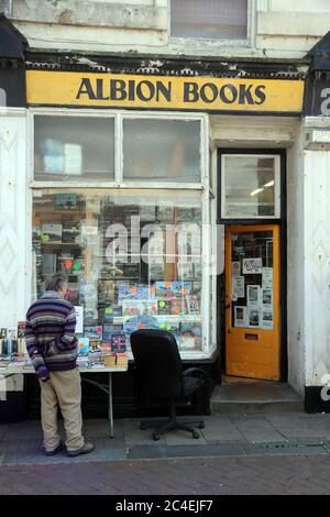 Uomo che guarda in Old Bookshop con finestra baia Foto Stock