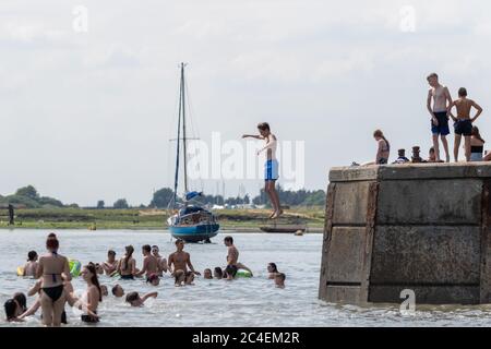 Leigh-on-Sea, Regno Unito. 26 Giugno 2020. La gente salta fuori dal Bell Wharf nell'acqua fredda. La gente fuori a Leigh Vecchia, Essex, godendo il tempo caldo e le spiagge meno affollate. Penelope Barritt/Alamy Live News Foto Stock