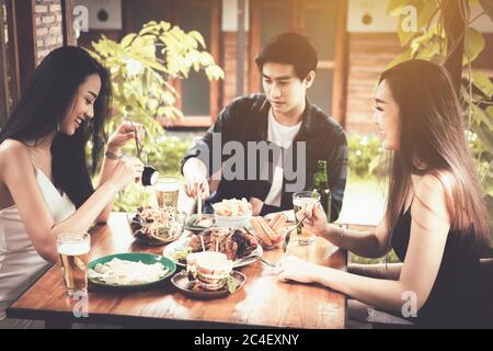 Amico asiatico che mangia cibo nel ristorante. Foto Stock