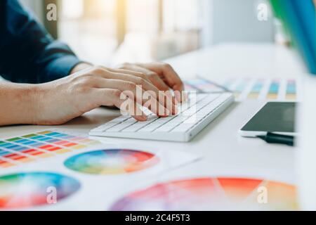 I progettisti stanno digitando le dita sulla tastiera del computer in un ufficio moderno. Foto Stock