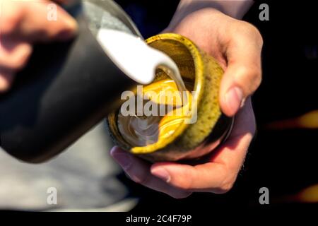 Primo piano di un maschio che fa un latte art Foto Stock