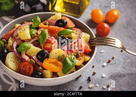 Insalata di patate con pomodori, olive, capperi, cipolla rossa, cucina italiana. Insalata Pantesca. Foto Stock