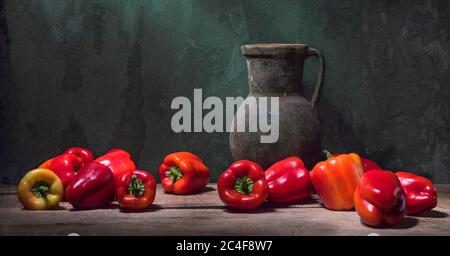 Ancora vita con paprika campana rossa e una grande caraffa antica sullo sfondo di una parete incrinata Foto Stock