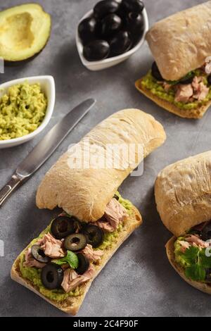 Bruschetta con tonno, olive e avocata spalmata. Foto Stock