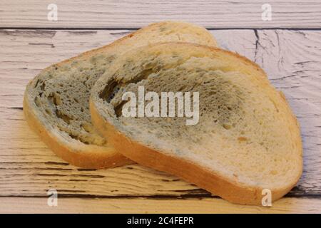 Muffa che cresce rapidamente su pane ammuffito su sfondo di legno. Muffa su una fetta di pane. Pane raffermo, coperto di muffa. Foto Stock