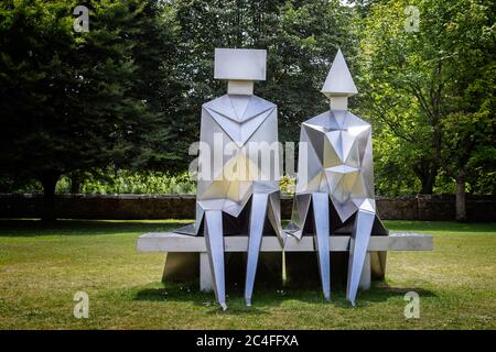 Coppia di lavoro in acciaio inossidabile sulla scultura di Bench di Lynn Chadwick, nei terreni della Cattedrale di Salisbury, Salisbury, Wiltshire, Regno Unito, il 19 giugno 2020 Foto Stock