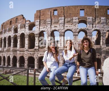 Giovani che si trovano di fronte al Colosseo nel tardo pomeriggio, IV Templum Pacis, Roma, Regione Lazio, Italia Foto Stock