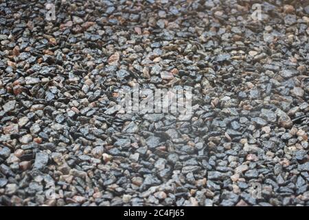 Piccole pietre irregolari naturali grigie struttura sfondo industriale per interni o esterni Foto Stock