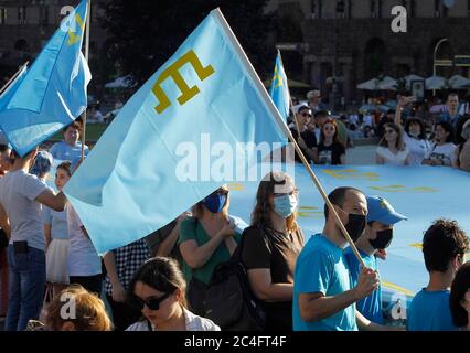 I Tatari di Crimea hanno bandiere nazionali durante la celebrazione. I Tatari di Crimea celebrano annualmente il giorno della bandiera del Tatar di Crimea il 26 giugno. La bandiera dei Tatari Crimea è un panno blu con un emblema giallo - Tanga - nell'angolo in alto a sinistra. La bandiera fu adottata per la prima volta dal Kurultai (congresso nazionale) dei Tatari di Crimea nel 1917, dopo la Rivoluzione di febbraio in Russia. Il 30 giugno 1991, il Kurultay recentemente convocato ha riadottato questa bandiera come nazionale, secondo Wikipedia. Foto Stock