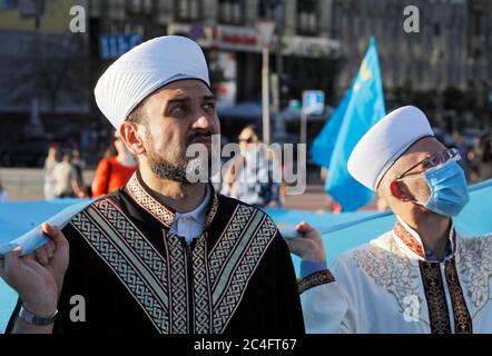 I Tatari di Crimea hanno bandiere nazionali durante la celebrazione. I Tatari di Crimea celebrano annualmente il giorno della bandiera del Tatar di Crimea il 26 giugno. La bandiera dei Tatari Crimea è un panno blu con un emblema giallo - Tanga - nell'angolo in alto a sinistra. La bandiera fu adottata per la prima volta dal Kurultai (congresso nazionale) dei Tatari di Crimea nel 1917, dopo la Rivoluzione di febbraio in Russia. Il 30 giugno 1991, il Kurultay recentemente convocato ha riadottato questa bandiera come nazionale, secondo Wikipedia. Foto Stock