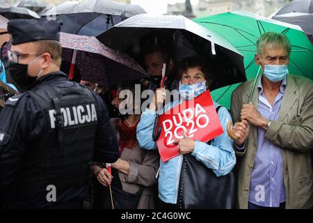 Cracovia, Polonia minore, Polonia. 21 Giugno 2020. Un sostenitore politico di Andrzej Duda con un cartello e un ombrello durante il raduno.a sostegno dell'attuale presidente della Polonia, Andrzej Duda, che sta facendo domanda per le rielezioni presidenziali che si terranno il 28 giugno, si è tenuto un raduno politico. Il rally è stato accompagnato dai suoi anziani stabili dell'elettorato e dai piccoli abitanti conservatori della città. Una controricorrente è stata tenuta contro le dichiarazioni omofobiche di Duda. Credit: Filip Radwanski/SOPA Images/ZUMA Wire/Alamy Live News Foto Stock