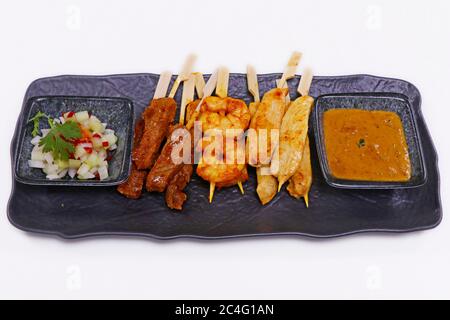 specialità indonesiane spiedino satay con pollo, mutone e gamberi con salsa di arachidi Foto Stock