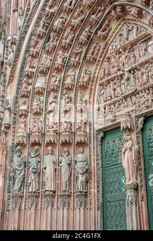 Particolare della porta con incisioni di figure religiose sulla facciata ovest della Cattedrale di Notre Dame, nella città di Strasburgo, Alsazia a est Foto Stock