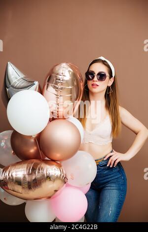 vacanze e concetto di moda - ragazza felice giovane o adolescente con palloncini elio Foto Stock