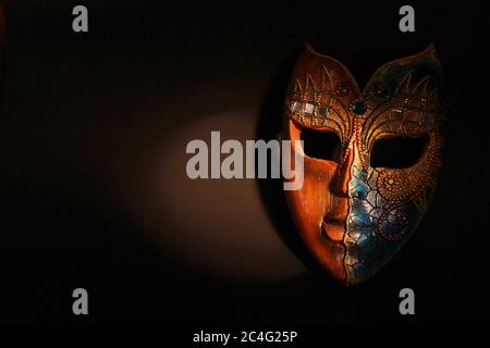 Bella maschera di legno marrone con gemme e progettando su di esso in luce drammatica del punto Foto Stock