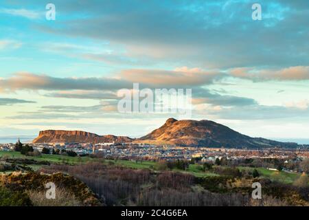 Vista in tarda serata attraverso Edimburgo sud fino a Arthur's Seat e Salisbury Crags, dalle Braid Hills, Edimburgo. Foto Stock