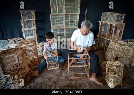 CANH Hoach villaggio, Phuong Trung comune, Thanh OAI distretto (Hanoi), Vietnam - 26 maggio 2020: Immagine di un artigiano sta facendo gabbie di uccelli. Il professi Foto Stock