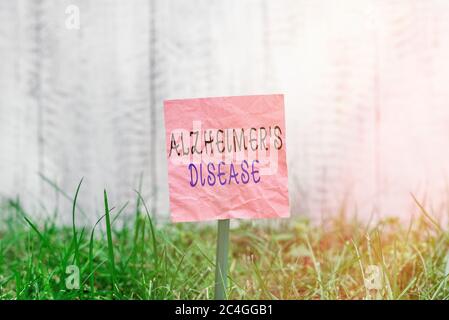 Scrittura concettuale della mano che mostra la malattia di Alzheimers. Concetto che significa disturbo irreversibile del cervello che distrugge lentamente la memoria carta comune attaccata alla st Foto Stock