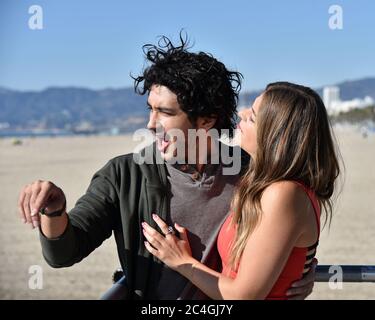 Una giovane coppia felice che si diverte su una spiaggia di sabbia Foto Stock