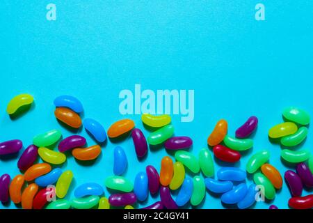Jelly Beans assortiti bordo con copyspace su sfondo blu Foto Stock