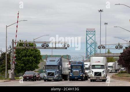 Camion e veicoli visti lasciare l'Ambassador Bridge da Detroit entrando in Canada dopo aver attraversato il confine tra Stati Uniti e Canada, ponte visto sullo sfondo Foto Stock