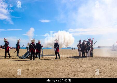 Malaga, Spagna - 26 ottobre 2014: Soldati francesi del XVIII secolo che sparano un cannone con polvere da sparo. Reenattori uomini e donne. Rievocazione storica di una N Foto Stock