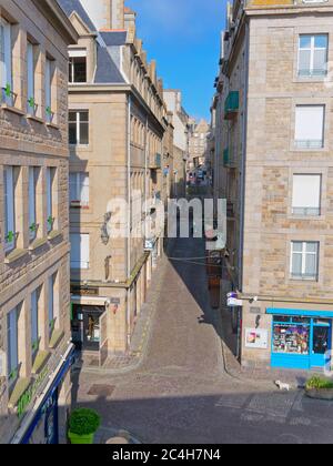 Saint Malo, Francia - 21 2019 maggio: Mattina presto guardando su Rue du Puits aux Braies a Saint Malo, Francia. Un pulitore della strada lavora fuori un caffè. All'altezza di Foto Stock