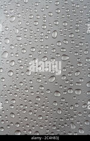 Gocce d'acqua su sfondo grigio. Superficie metallica con gocce d'acqua. Foto Stock