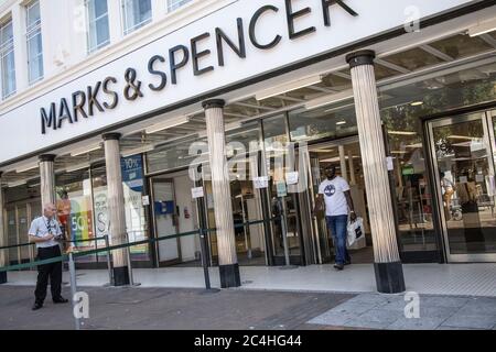 Londra, Regno Unito. 27 giugno 2020. Un acquirente lascia un grande magazzino Marks & Spencer su Kingston Upon Thames High Street mentre i clienti tornano lentamente nelle strade alte, prima di migliaia riaprirsi il 4 luglio, in quanto le restrizioni di blocco sono ulteriormente attenuate in tutta l'Inghilterra. 26 Giugno 2020, Kingston upon Thames, Southwest London, England, United Kingdom Credit: Clickpics/Alamy Live News Foto Stock