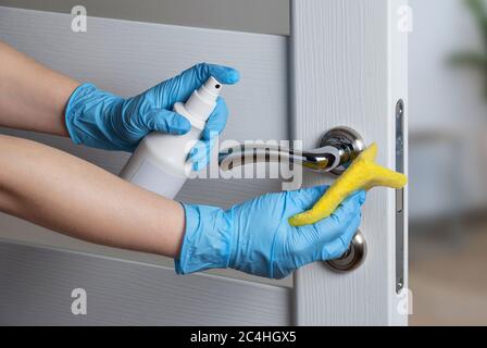 Pulizia delle maniglie delle porte con antisettico durante un'epidemia virale Foto Stock