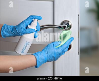 Pulizia sterile delle maniglie delle porte durante una pandemia di coronavirus. Detergente a base di alcol, guanti e un tovagliolo. Foto Stock