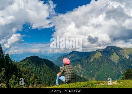 Passo Jalori, Himachal Pradesh, India; 20-settembre-2019; un trekking da solo che gode la vista sulle montagne, passo Jalori, Himachal Pradesh, India Foto Stock