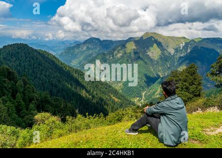 Passo Jalori, Himachal Pradesh, India; 20-settembre-2019; un trekking da solo che gode la vista sulle montagne, passo Jalori, Himachal Pradesh, India Foto Stock