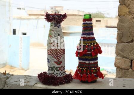 Artigianato Sindhi: Involucri colorati con perline per bottiglie con frange tessute. Fatto a mano in un villaggio di Tharparkar. Colorato e dettagliato. Foto Stock