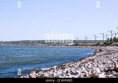 Pescatore sulla spiaggia in estate di granito vicino alla ferrovia Foto Stock