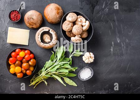 Ingredienti di funghi garlicky al forno, formaggio cheddar portabello e salvia su fondo nero. Vista dall'alto, spazio per il testo Foto Stock