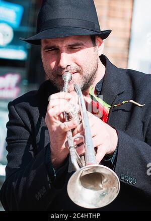 Busker per le strade di Truro, Cornovaglia suona la sua tromba Foto Stock