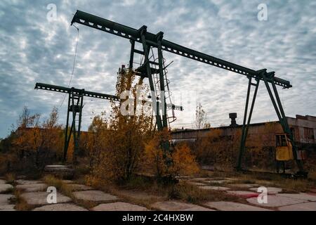 Vecchia gru a ponte a portale arrugginita in area industriale abbandonata. Foto Stock