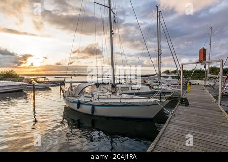 Barche a vela in un porto turistico durante un bellissimo tramonto colorato al Mar Baltico Foto Stock
