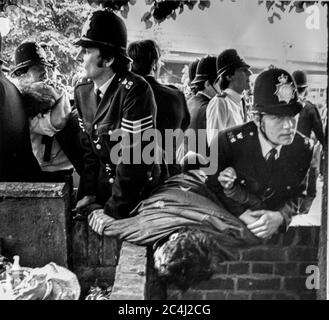 Gli ufficiali di polizia trattengono e arrestano due manifestanti al Notting Hill Carnival di Londra nel 1978 Foto Stock