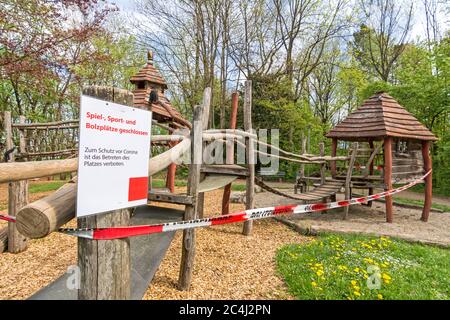 Parco giochi chiuso con nastro di polizia e cartello di avvertimento (testo tedesco: Parco giochi chiuso) a causa del virus Corona (Covid-19) Foto Stock