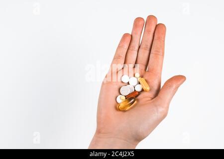 Pillole di diversi tipi e forme in mano. Foto Stock