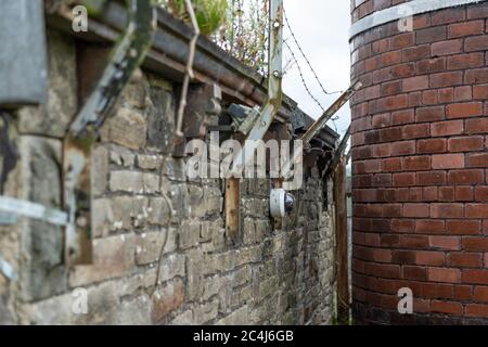 Messa a fuoco superficiale di una telecamera TVCC IP appena installata all'esterno di una vecchia parete di fabbrica. Foto Stock