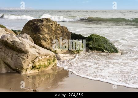 Groyne con rocce a Avon spiaggia Mudeford con Isola di Wight in distanza Foto Stock