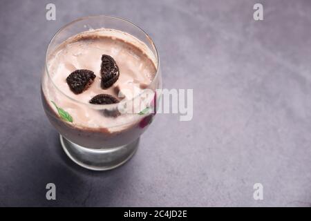 il latte di cioccolato agita in un bicchiere su sfondo nero. Foto Stock
