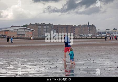 Portobello, Edimburgo, Scozia, Regno Unito. 27 giugno 2020. Non molto affollato al mare e lungomare il sabato pomeriggio, il tempo nuvoloso con una tempesta e pioggia pesante prima di ripulire per un po', Non ha interrotto una famiglia che si è scesi per un tuffo e la polizia auto con due ufficiali che non hanno avuto alcun motivo per bagnarsi. Foto Stock