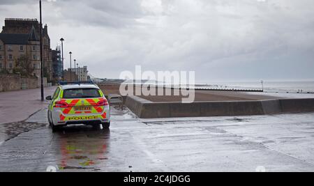 Portobello, Edimburgo, Scozia, Regno Unito. 27 giugno 2020. Non molto affollato al mare e lungomare il sabato pomeriggio, il tempo nuvoloso con una tempesta e pioggia pesante prima di ripulire per un po', Non ha interrotto una famiglia che si è scesi per un tuffo e la polizia auto con due ufficiali che non hanno avuto alcun motivo per bagnarsi. Foto Stock