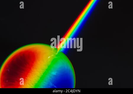 Colori dell'arcobaleno prodotto di luce rotta, che mostrano lo spettro della luce che viene piegata da un oggetto di vetro sferico fisica e ottica Foto Stock