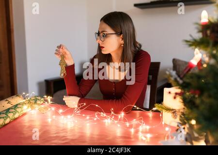 donna millenaria con decorazioni natalizie in un'atmosfera festosa Foto Stock